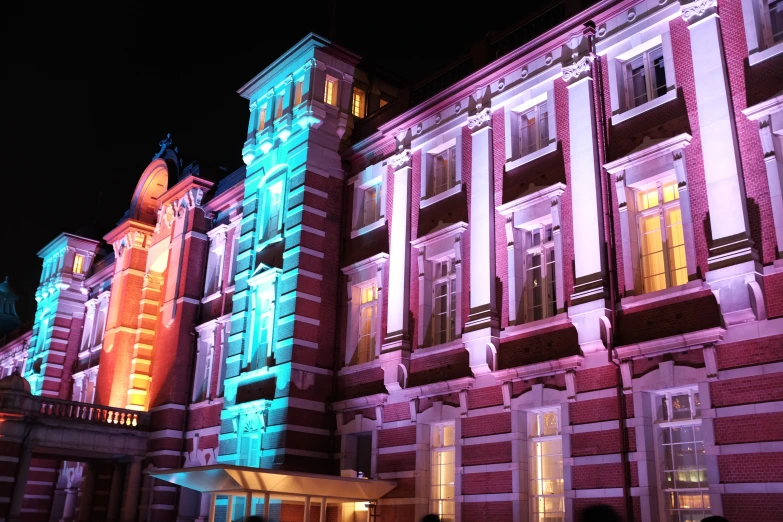 a group of buildings with lit up windows and clock on top