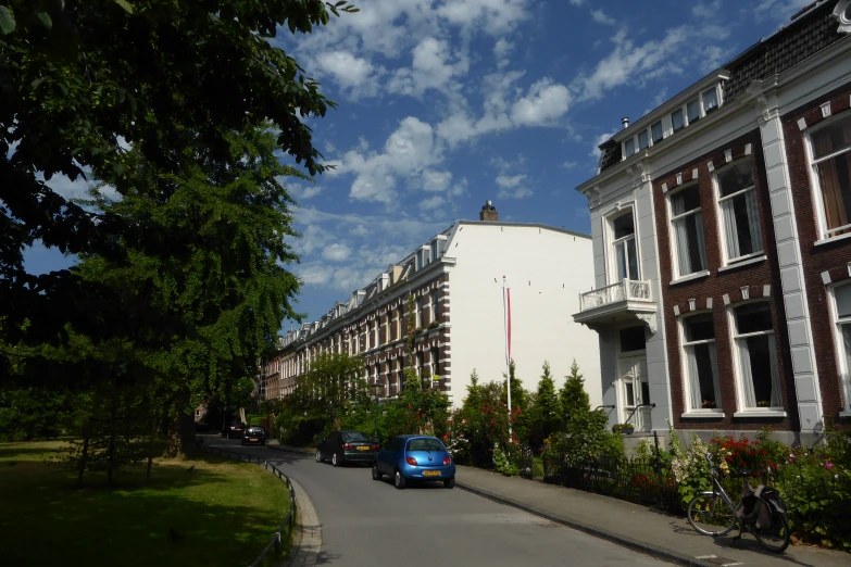 a view down a road in front of two buildings with cars