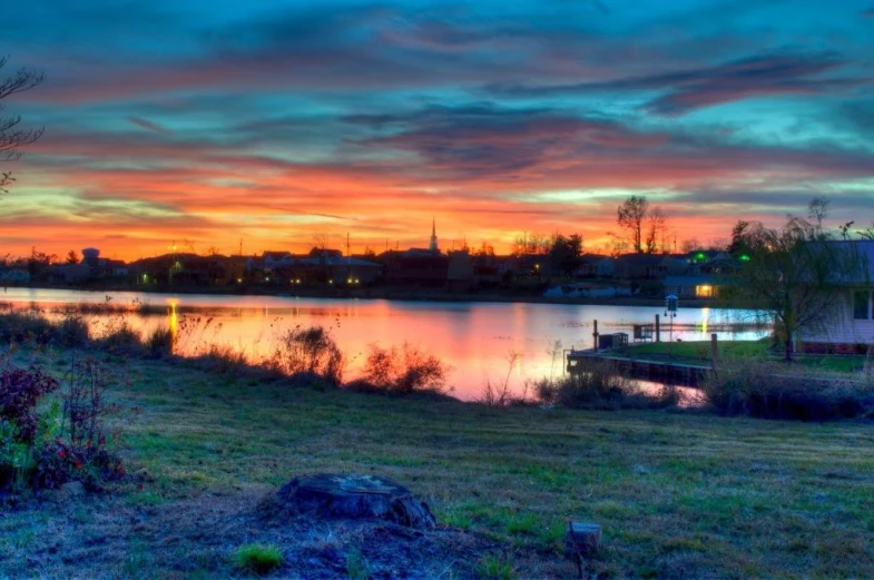 a beautiful sunset by a small river with lots of water