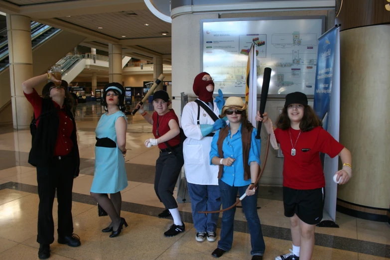 a group of young people wearing costumes with swords in an airport