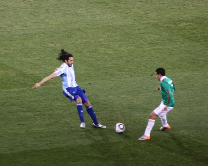 the soccer player controls the ball as another is dribble through it