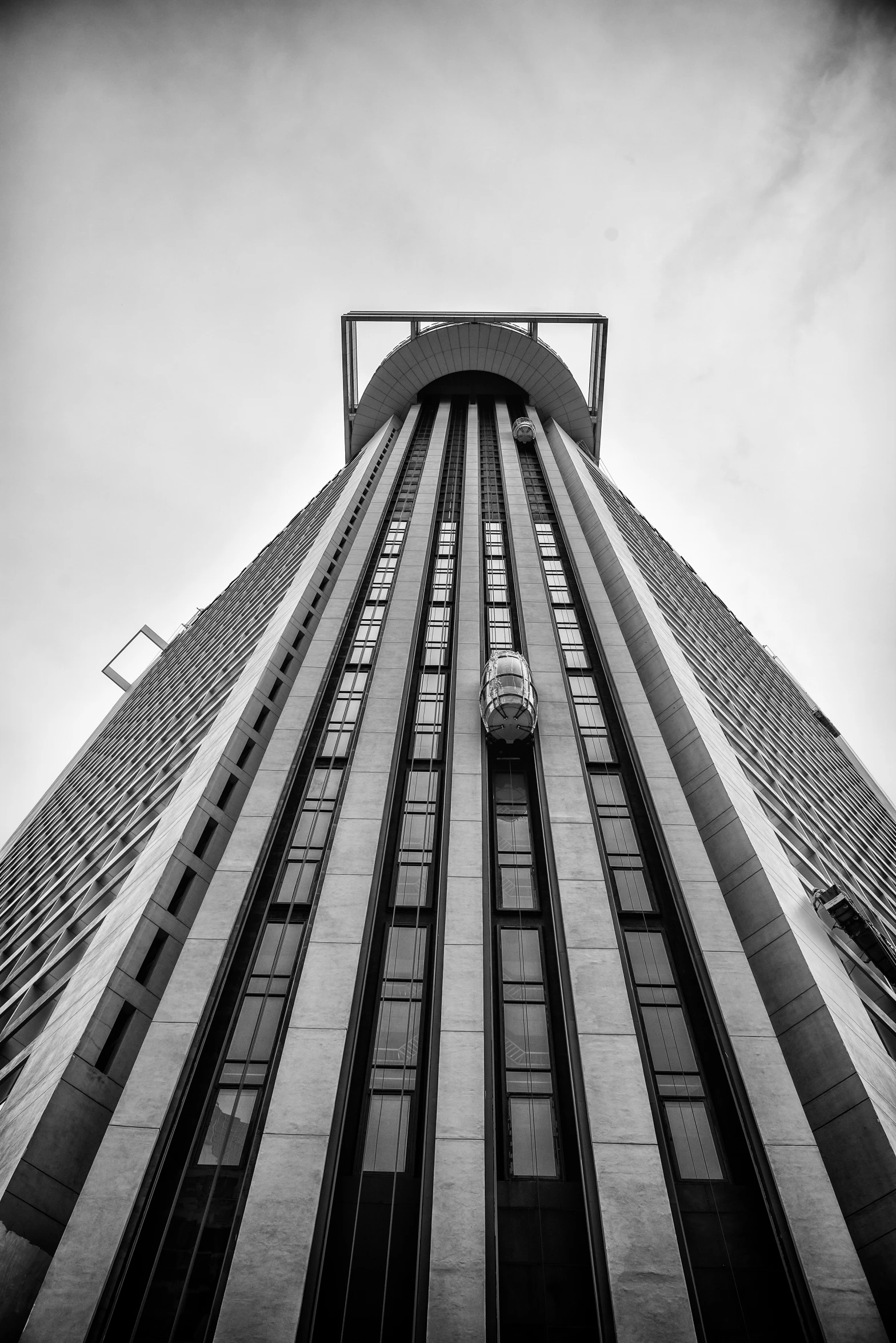 the side of a very tall building under a cloudy sky