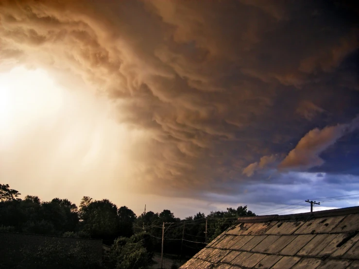 the rain clouds are coming over the roofs