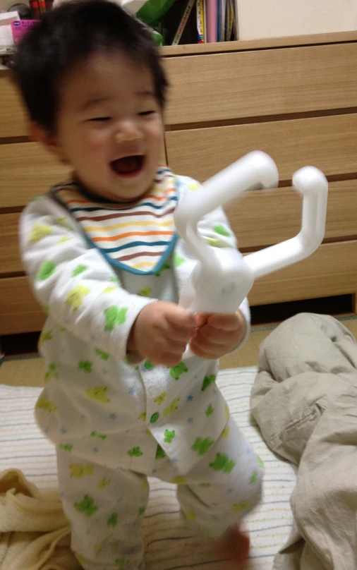 a baby in pajamas playing with an interactive device