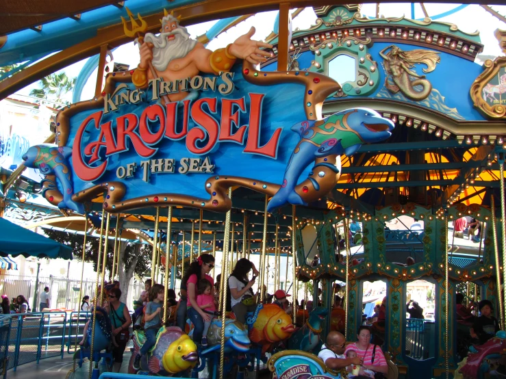 people on a merry go round with some horses