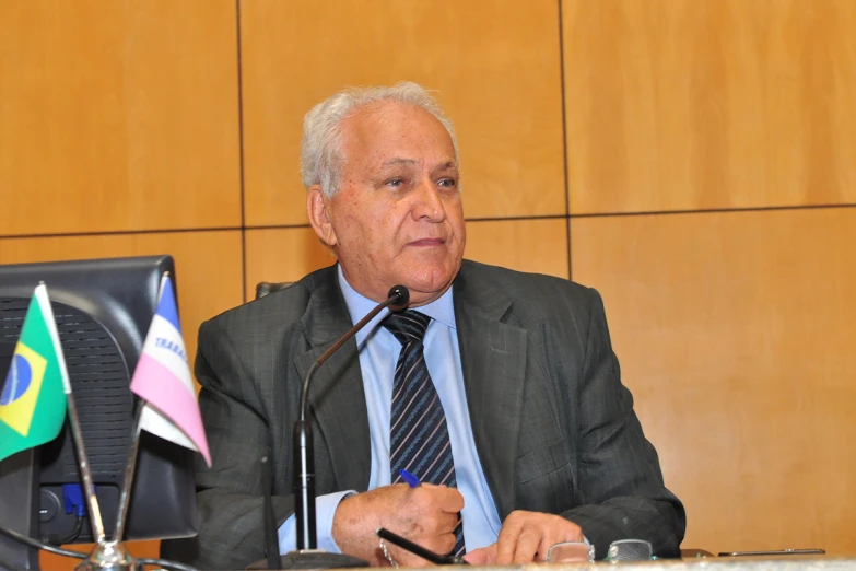 a man sitting at a desk in front of a microphone