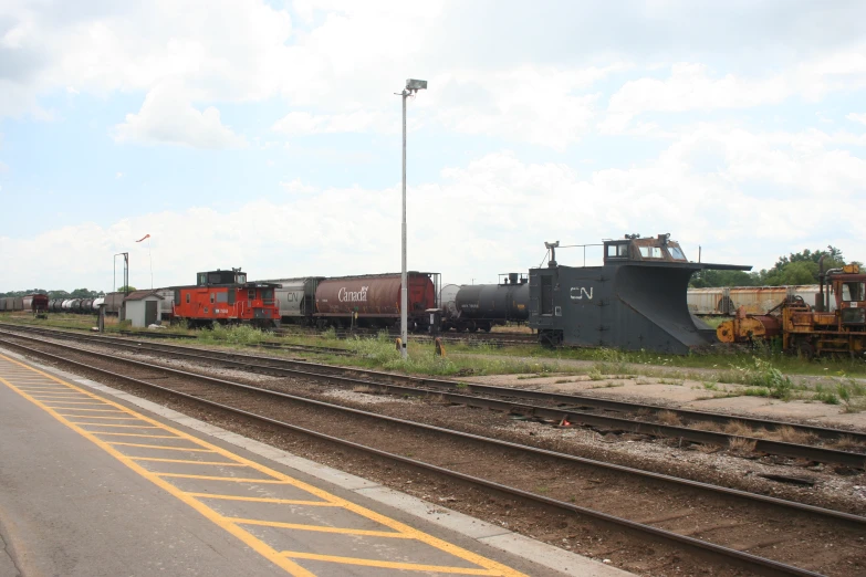 a train yard with several different trains on the tracks