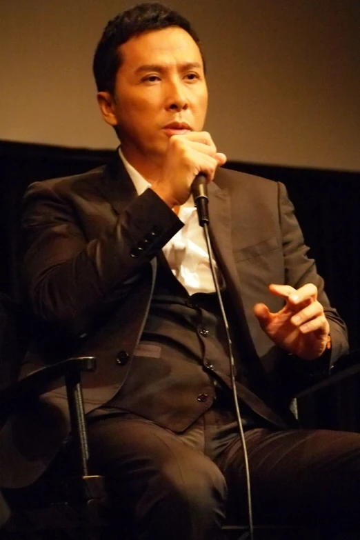 a man with his hand on the microphone