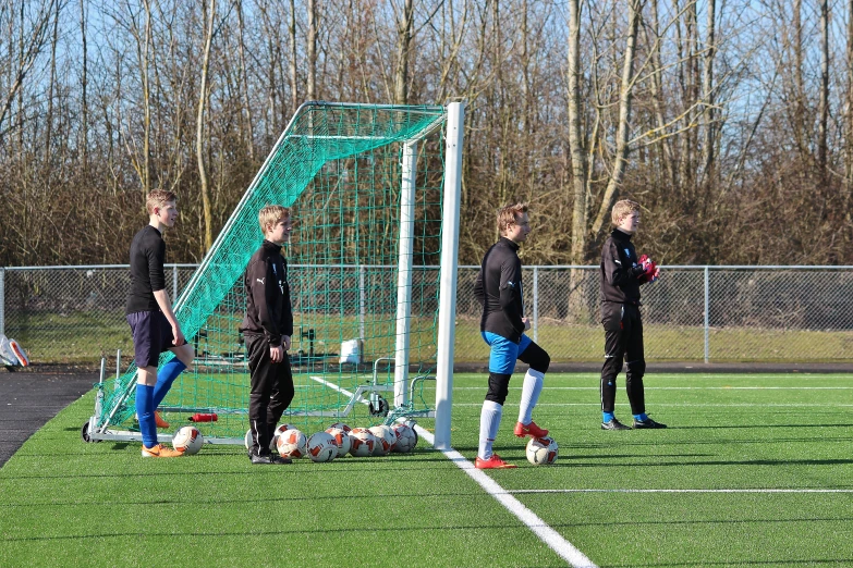 people are gathered around a goal in the field