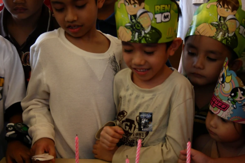 children in party hats looking at their cake