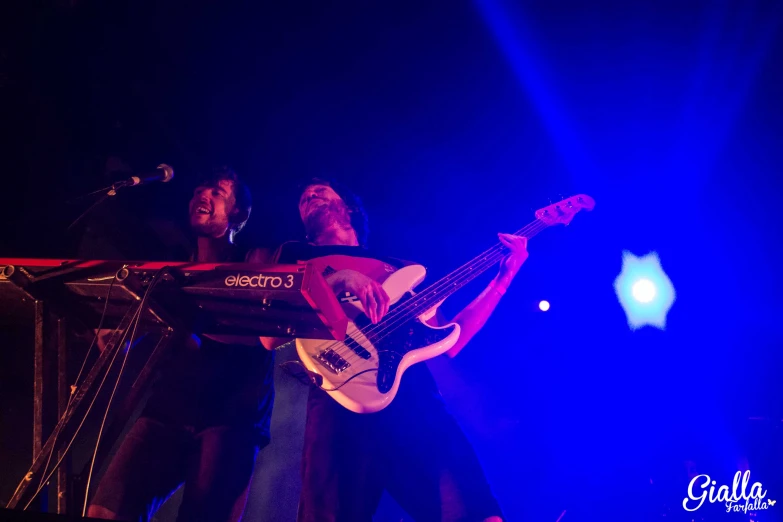 a man standing on a stage playing a guitar