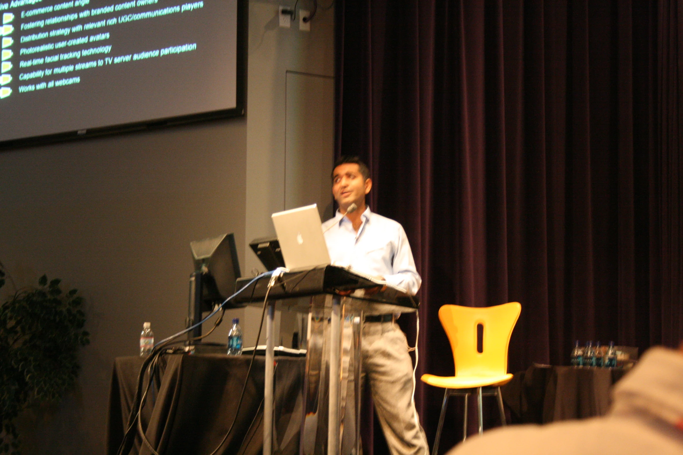 a man standing behind a podium with a laptop