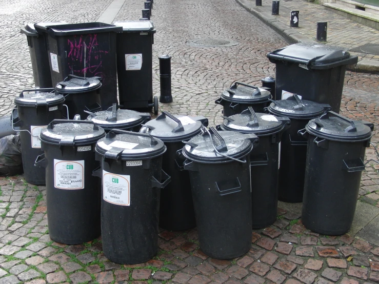 black trash cans lined up with stickers on them