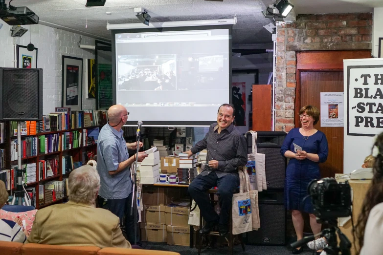 a group of people are standing and watching a projector