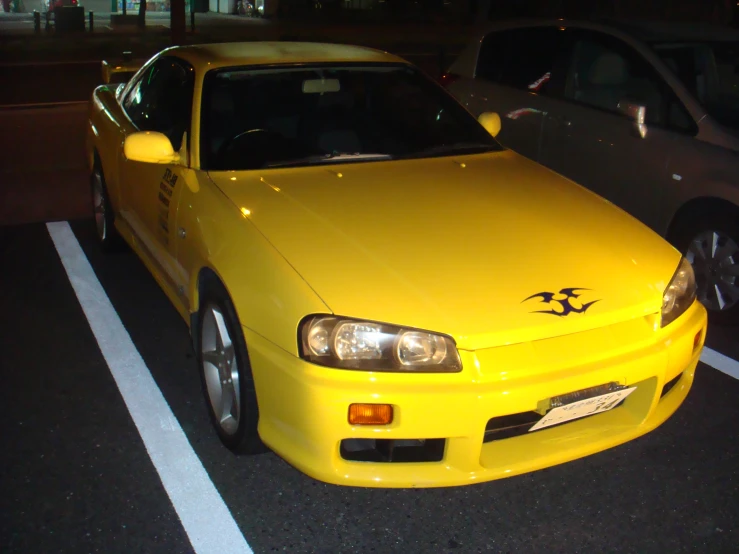 the yellow car is parked in the parking lot