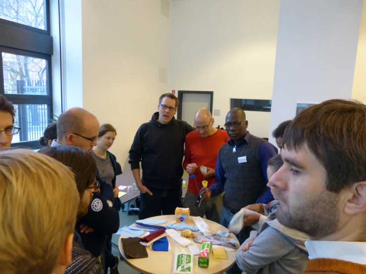 a group of people gather around a table