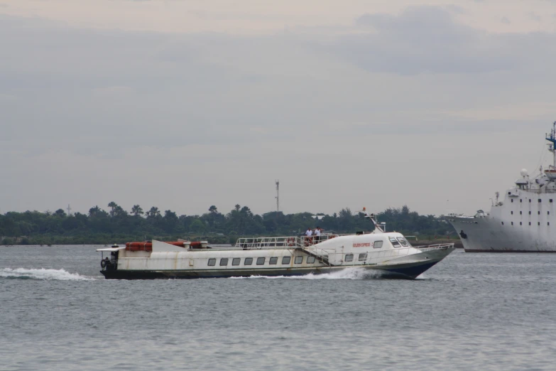 the ship is pulling the smaller boat behind it