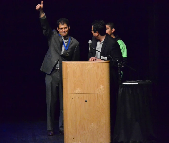 a man giving the finger up from a podium