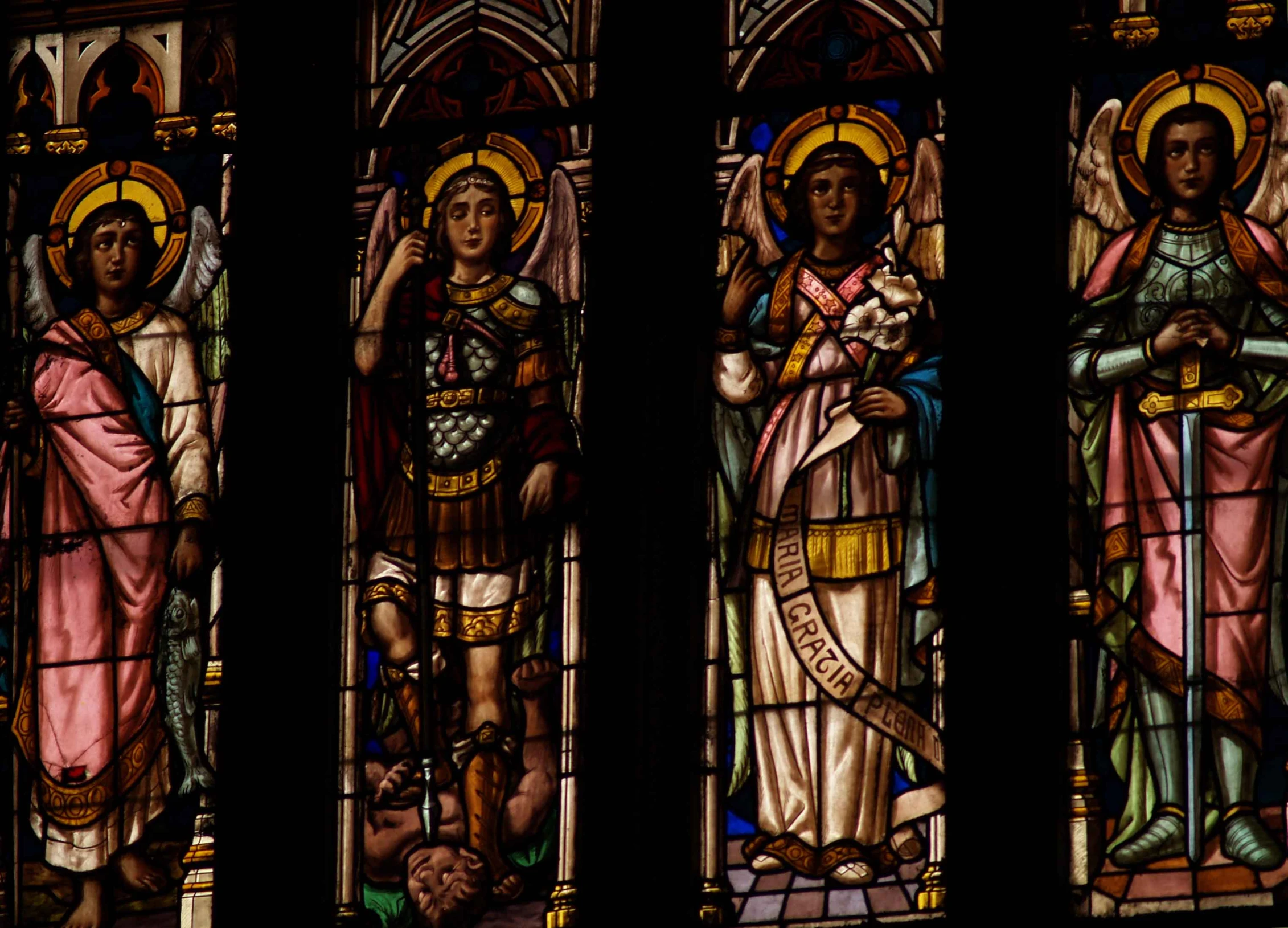 three stained glass windows depicting religious icons and angels