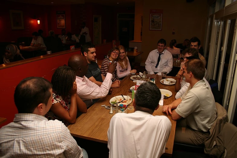 a group of people sitting at a table eating food