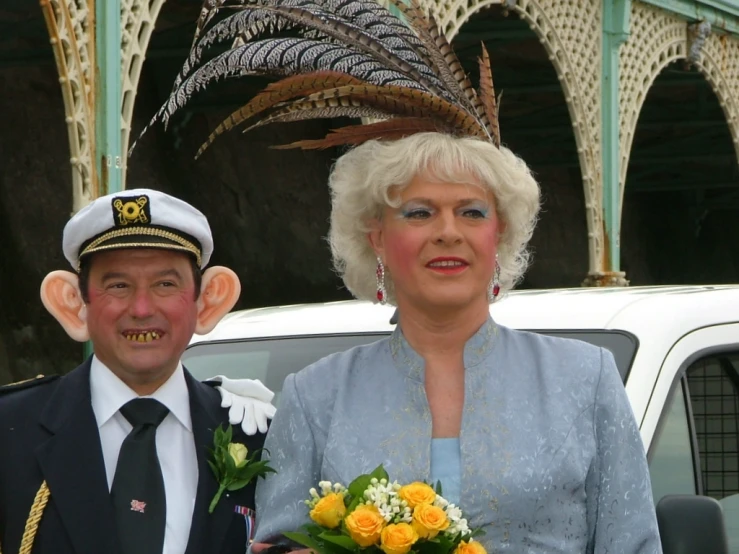 a man with a weird hat standing next to an older woman