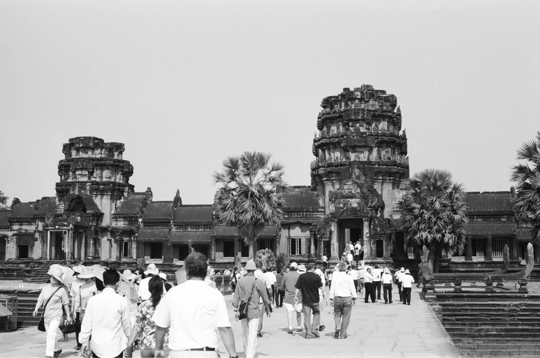 many people walk around an old building