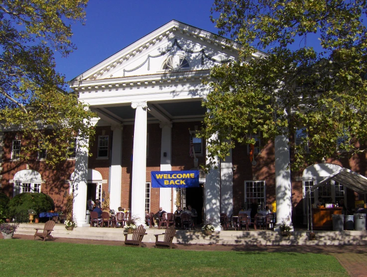 a white and brick building with a sign above it