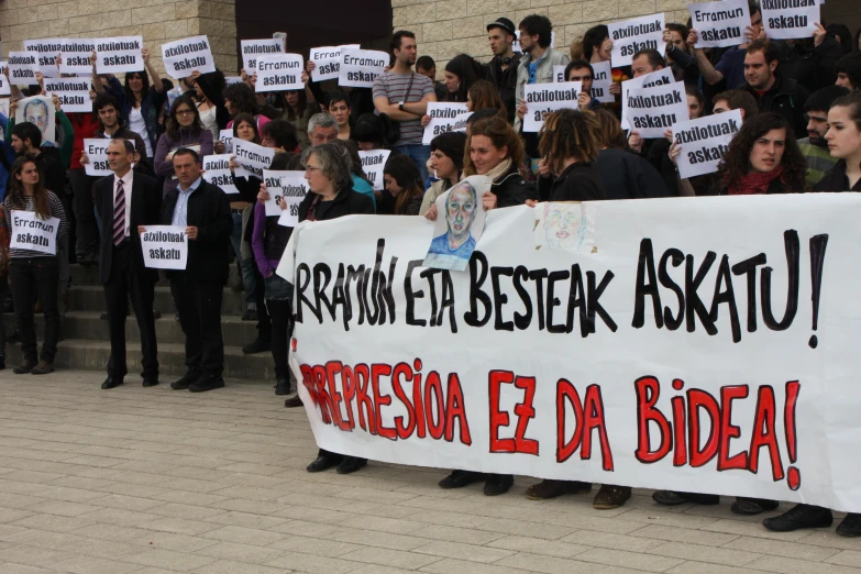 a large crowd of people holding signs in the street