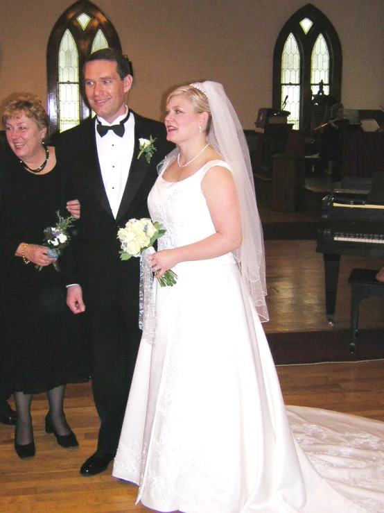 the bride and groom are taking pictures in front of their parents