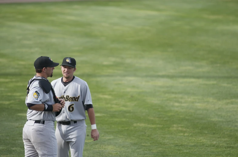 two baseball players standing on top of a baseball field