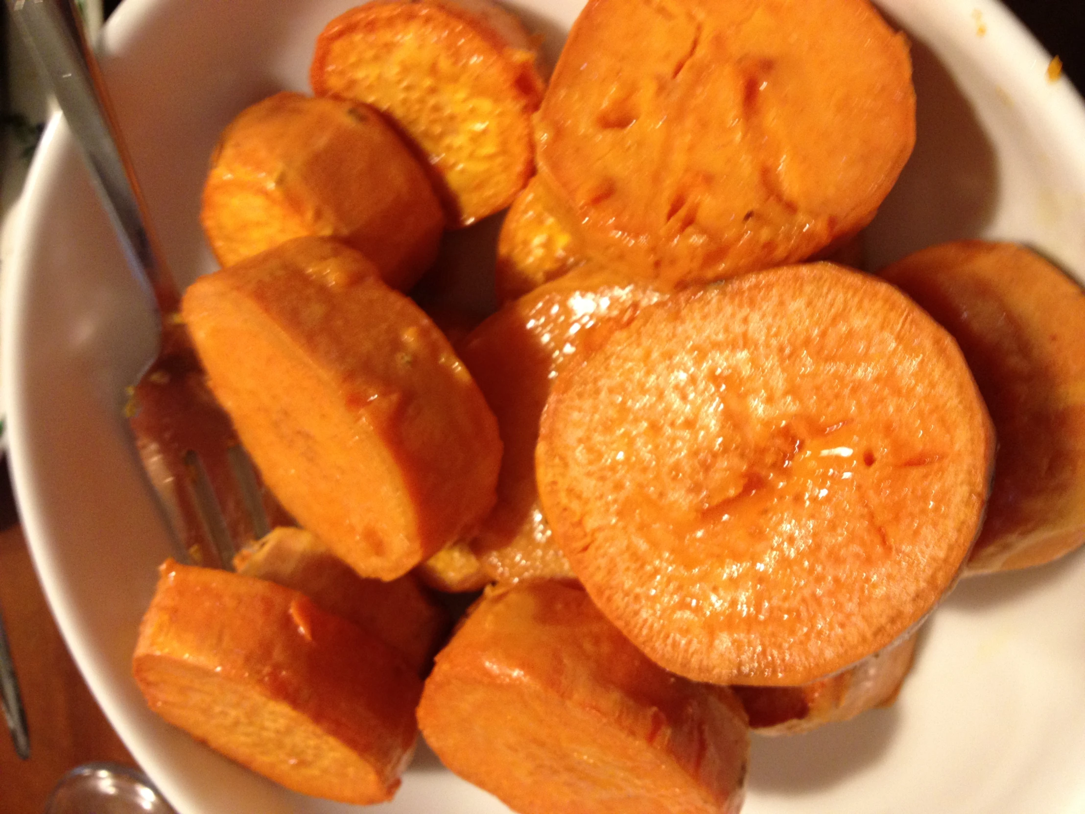 a bowl filled with cooked bananas and honey on top of a wooden table