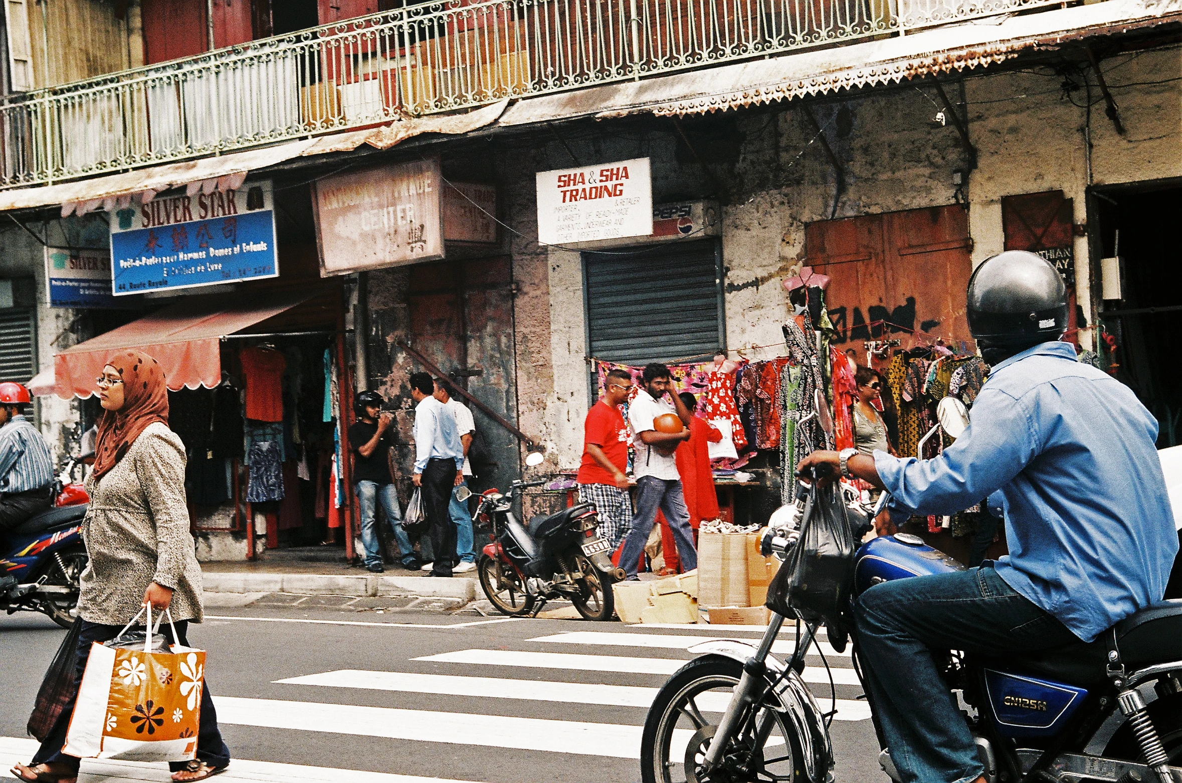 a man riding on the back of a motorcycle through a street