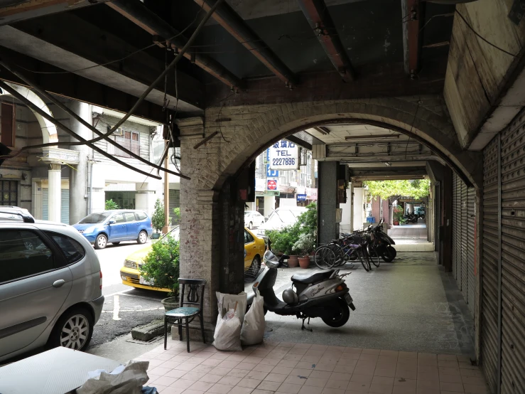 people sitting under an open patio with scooters parked in the shade