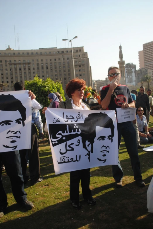 people hold placards depicting islamic leaders