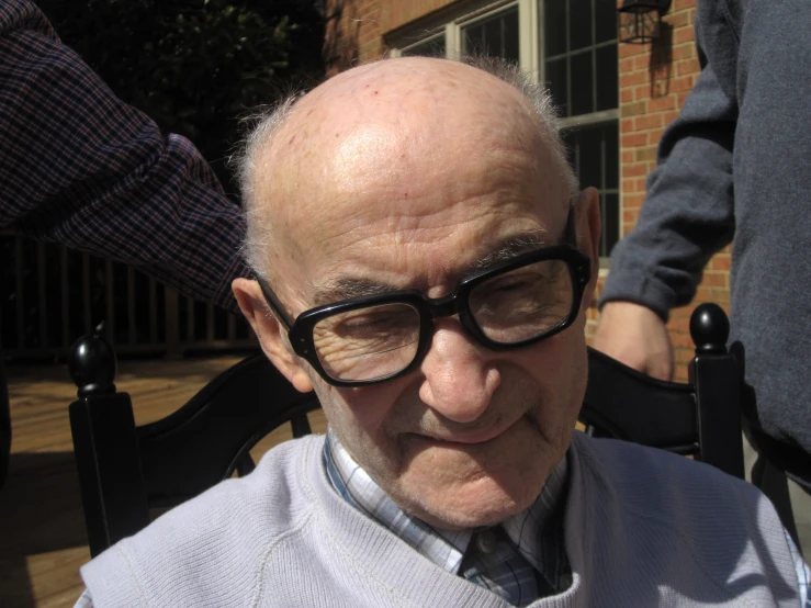 an older man with glasses on smiling at the camera