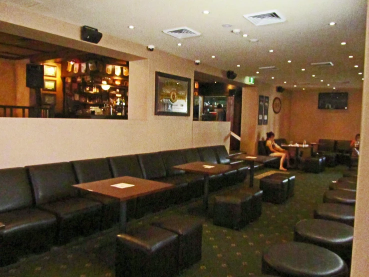 a restaurant with black leather couches and tables