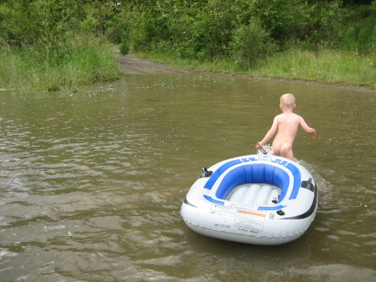 a boy in the water on a raft with his hand in the air