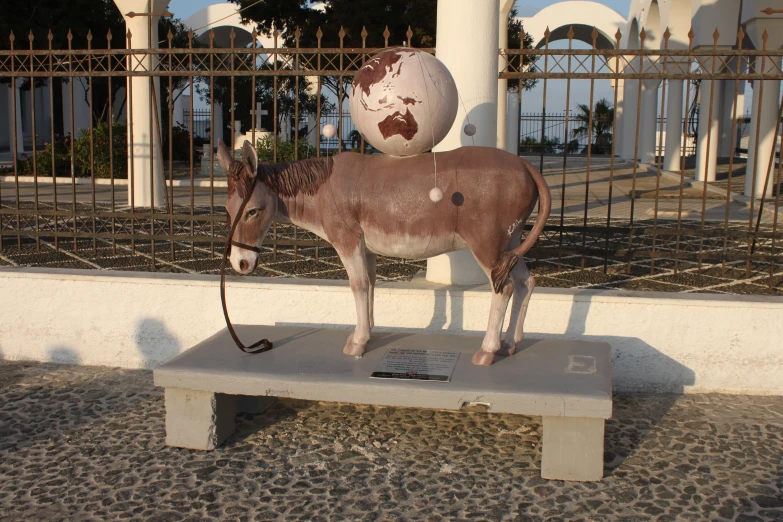 a statue of a horse sitting on a bench