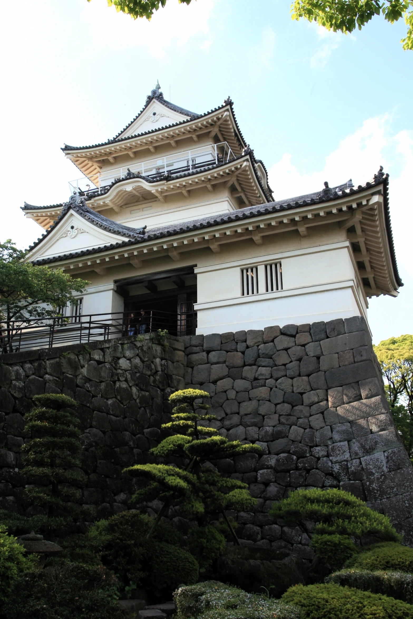 the building on top of a hill covered in trees and bushes