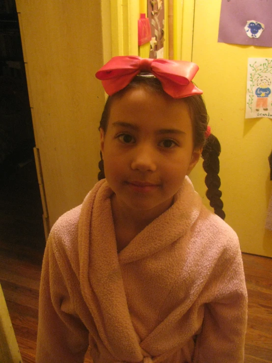 a little girl in her robe and hair bows