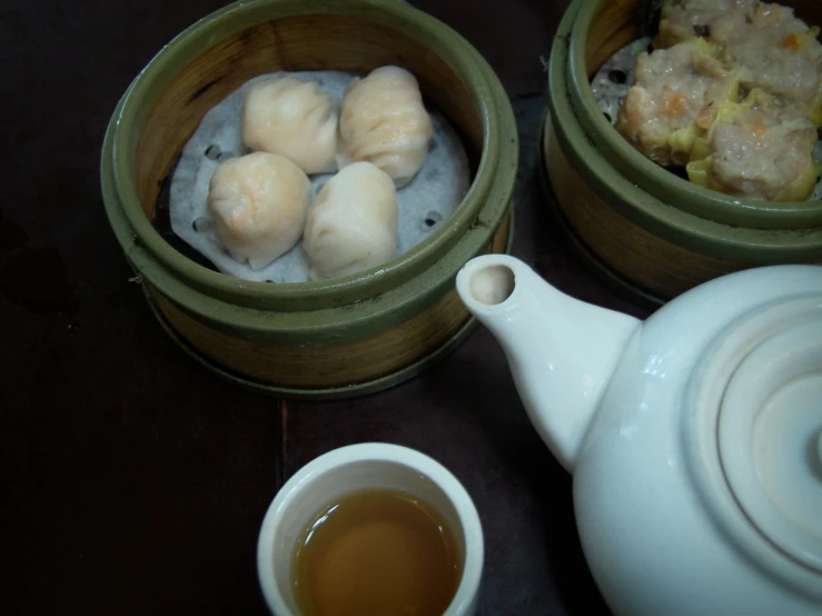 a tea pot is sitting beside an assortment of pastries