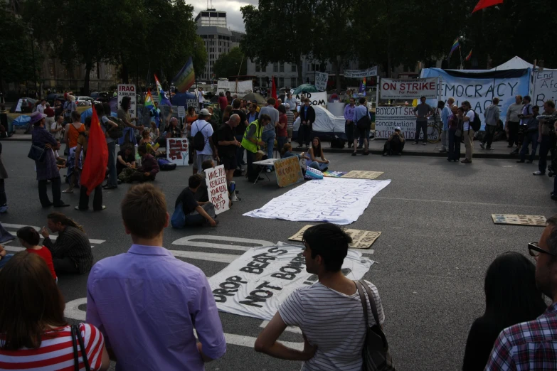 a group of people protesting outside with signs and banners