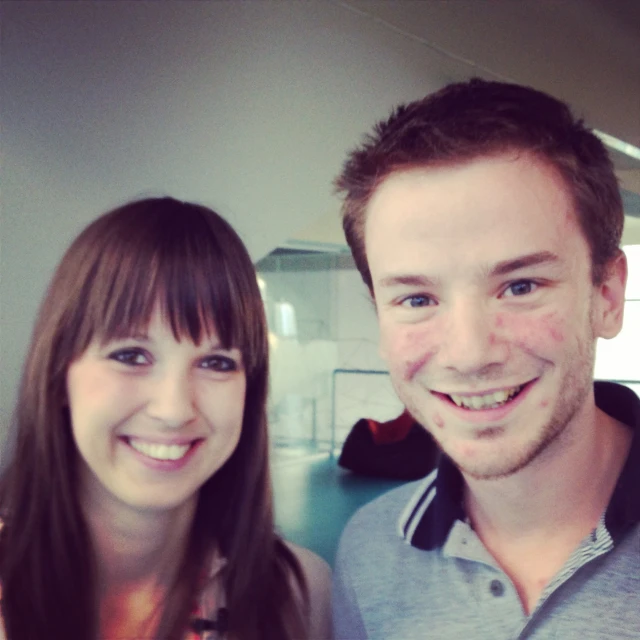 two people smile while posing for the camera