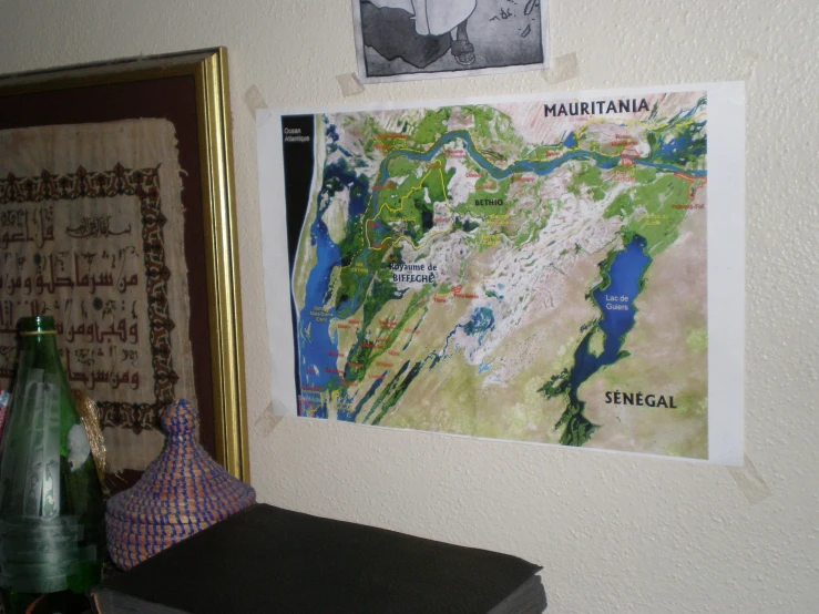 a map hanging on the wall above a wooden dresser