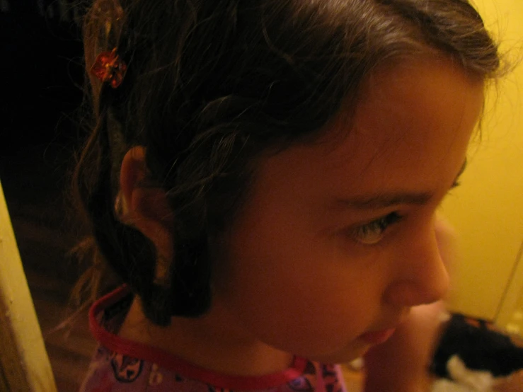 little girl staring ahead while holding soing in her hand