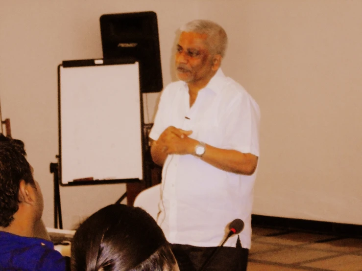 an older man is giving a presentation to people