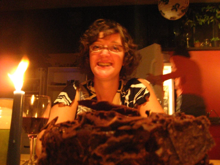 a smiling woman with glasses sitting in front of some dessert