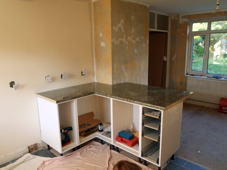 an unfinished kitchen is being worked on by the same person