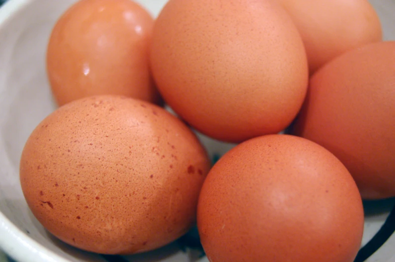 brown eggs in a bowl on top of a table