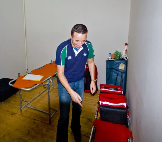 a man standing next to a chair with his back to him